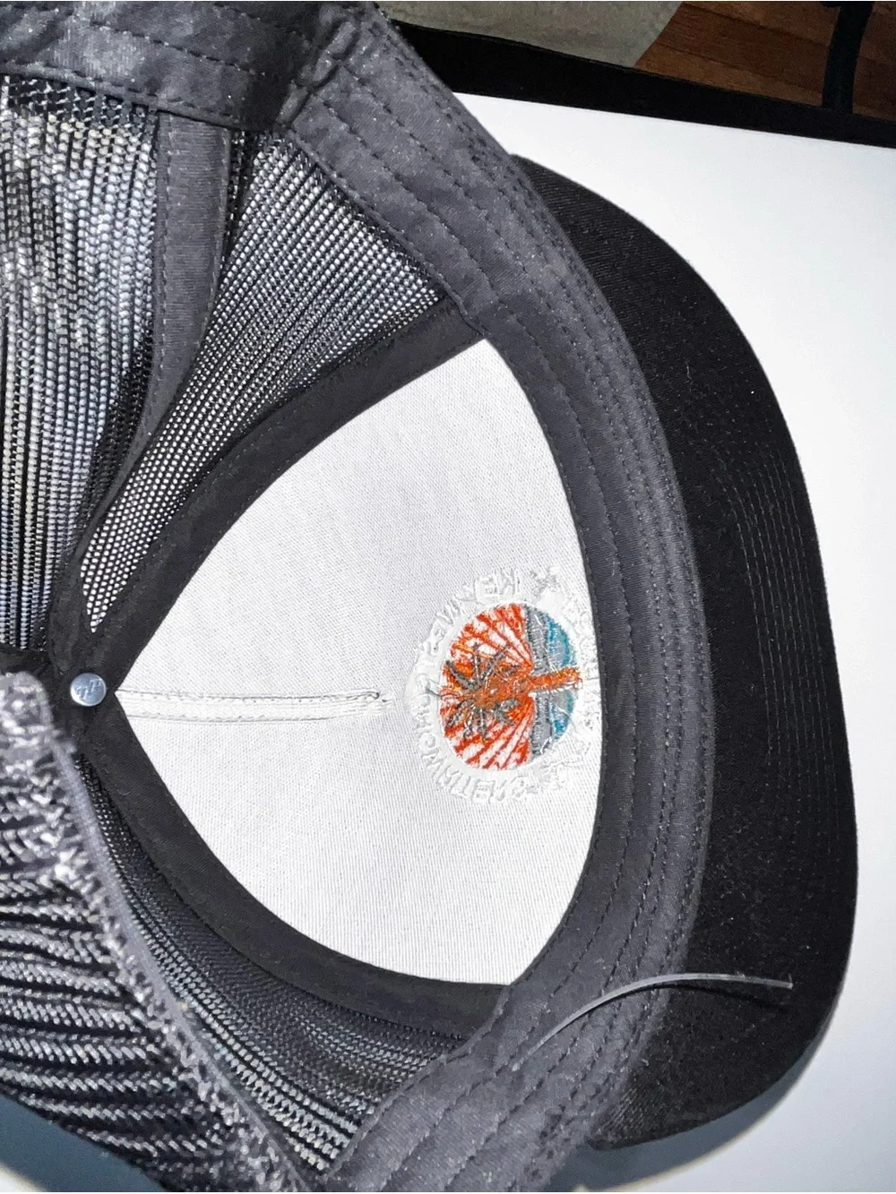 The Classic Black Snapback Hat with Orange and Blue Embroidered Logo